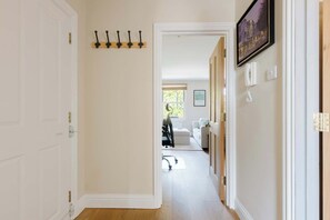 A hallway with a coat rack, a framed picture, and a telephone. - Gorgeous 1BDR Flat in the Heart of Clapham (Greater London)
