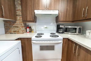 A kitchen with a stove, microwave, and coffee maker.