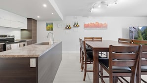Une cuisine moderne dotée d’un îlot central, d’une table à manger et de chaises.