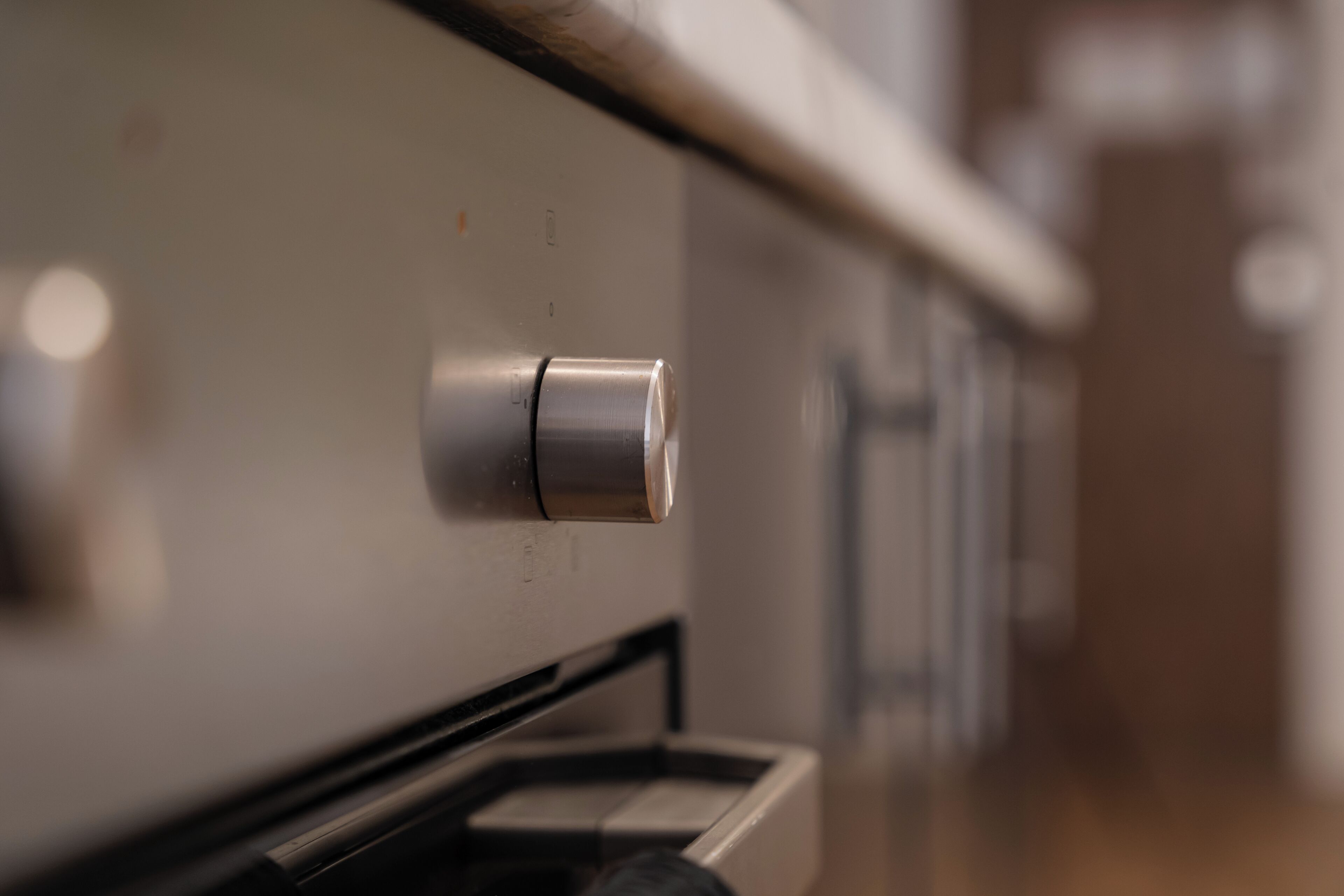 A close-up of a stainless steel appliance, likely a refrigerator or oven, with a control knob and a control panel.