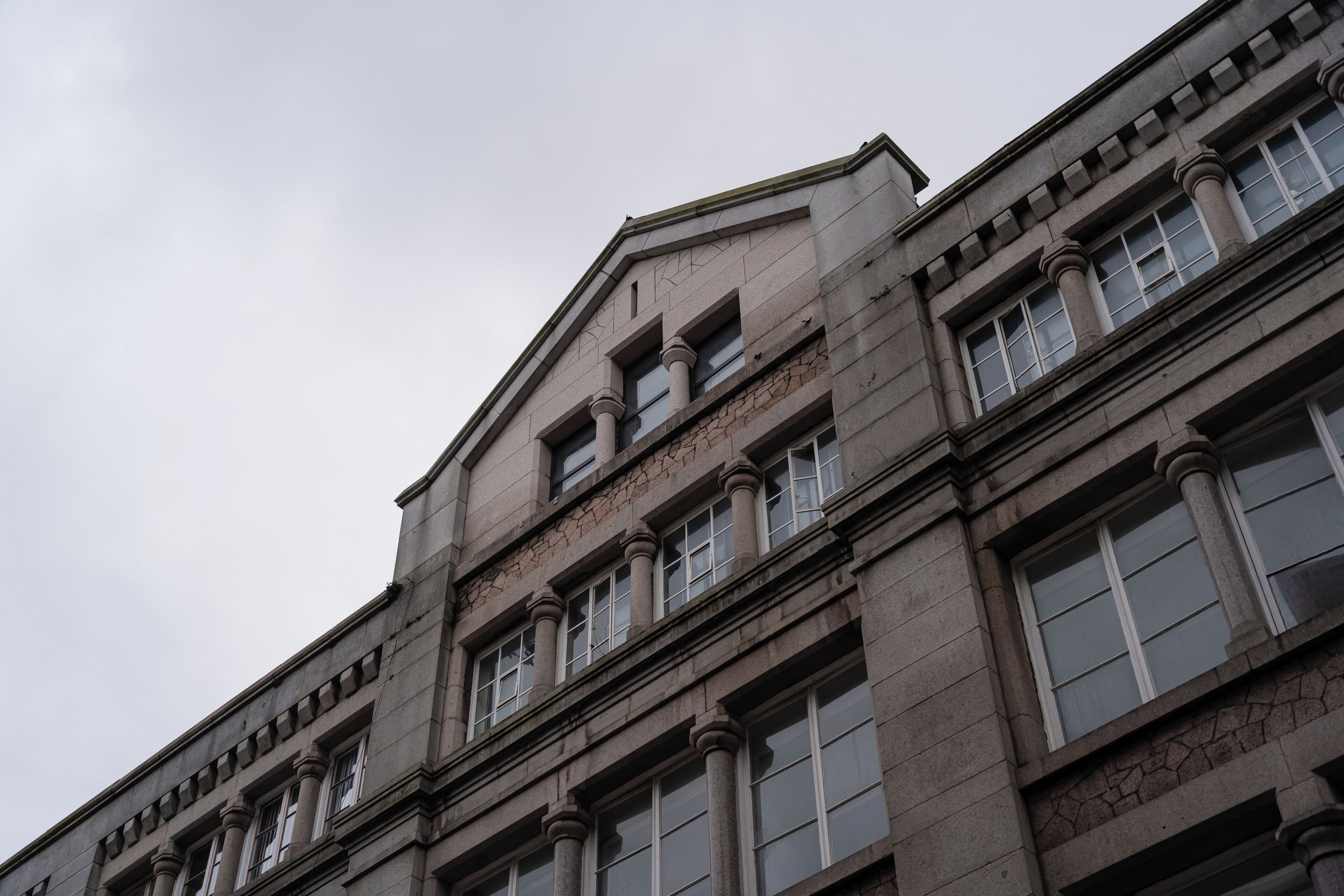 A multi-story building with a classical architectural style, featuring symmetrical windows and columns.