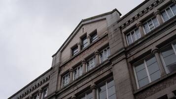 Un edificio de varias plantas con estilo arquitectónico clásico, que presenta ventanas y columnas simétricas.