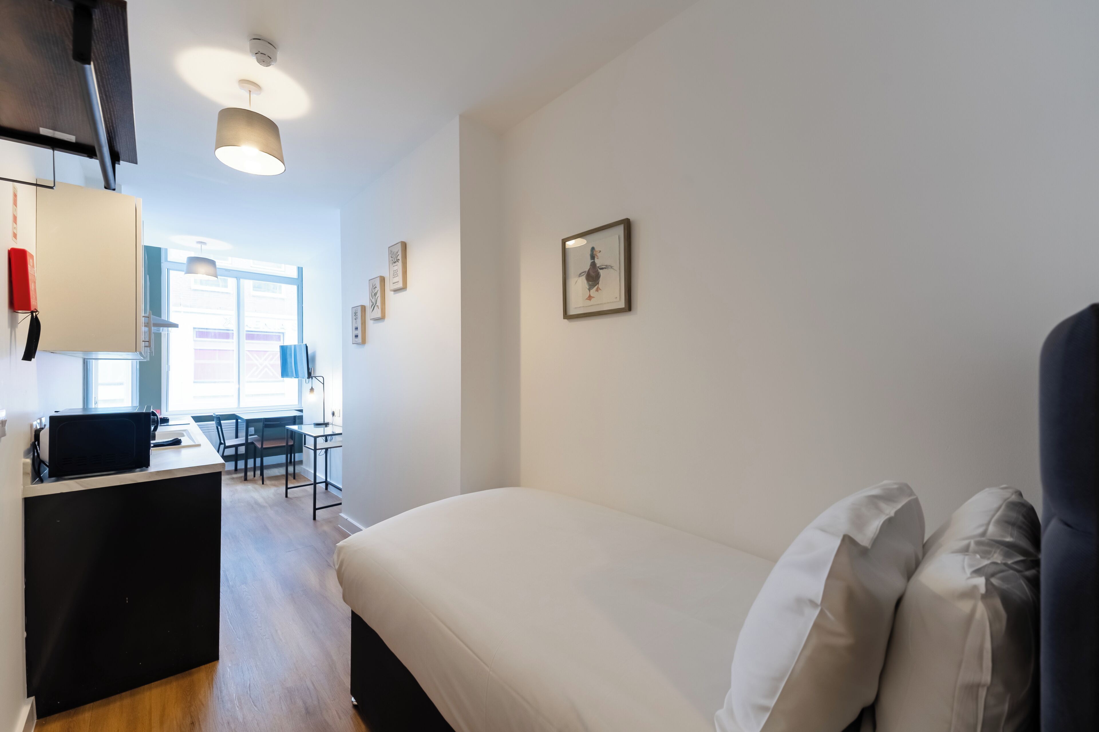 A bedroom with a bed, a desk, and a chair.