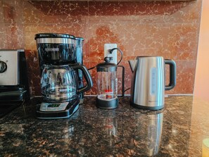 A kitchen with a coffee maker, a blender, and a kettle on a granite countertop. - Heart / Convention Center / King Bed / Elevator (Philadelphia)