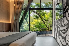 Quarto com janela ampla, uma cama e vista para árvores.
