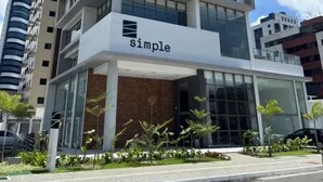 A modern multi-story building with a prominent 'simple' sign on the ground floor, surrounded by other high-rise buildings. - Simple Smart - Miramar Hospedagens (João Pessoa)