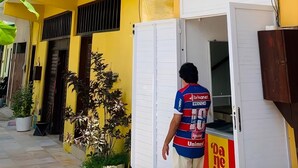 A yellow building with a sign reading 'ANAUA' and a person entering the building. - Pousada Anauá - Jericoacoara (Jijoca de Jericoacoara)