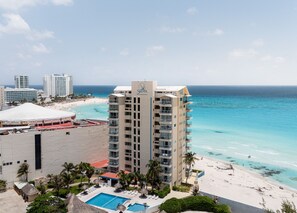 A high-rise hotel with a pool, beach, and ocean view. - Ocean View Studio Beachfront in Hotel Zone (Cancun)