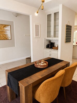 A dining area with a wooden table, black table runner, and two chairs.