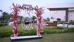 A garden with a floral archway and a sign reading 'ALCAZAR.' - The Most Luxurious Private Resort in Karachi (Karachi)