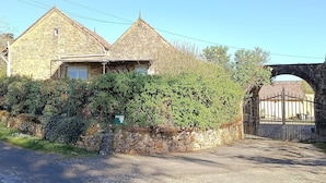 A stone building with a gated entrance, surrounded by greenery. - "La Borie" charming gîte with swimming pool in Daglan at Mas de Cause (Daglan)