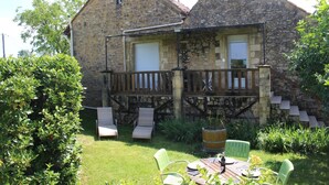 A stone building with a balcony, outdoor seating, and a grassy area. - "La Borie" charming gîte with swimming pool in Daglan at Mas de Cause (Daglan)