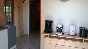 A kitchen with a coffee maker, toaster, and clock on the wall. - "La Borie" charming gîte with swimming pool in Daglan at Mas de Cause (Daglan)