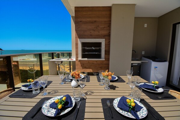 Un espace repas avec vue sur l’océan, un barbecue intégré et une petite cuisine.