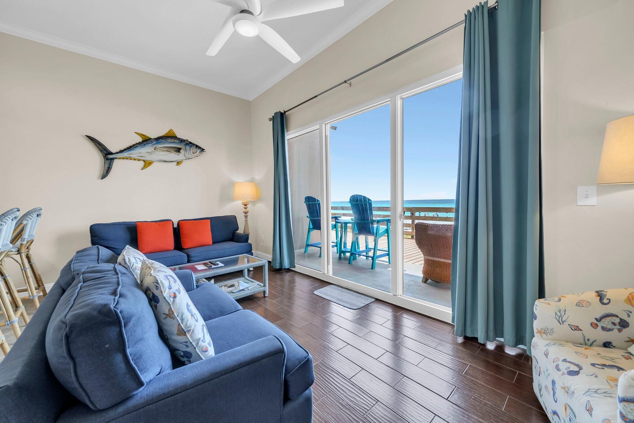 A living room with a sofa, a coffee table, and a fish wall art piece.