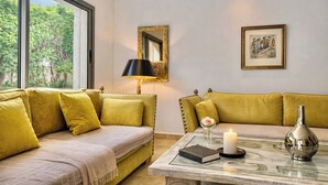Une pièce avec un canapé, une table sur laquelle se trouve un livre, une bougie et un vase.