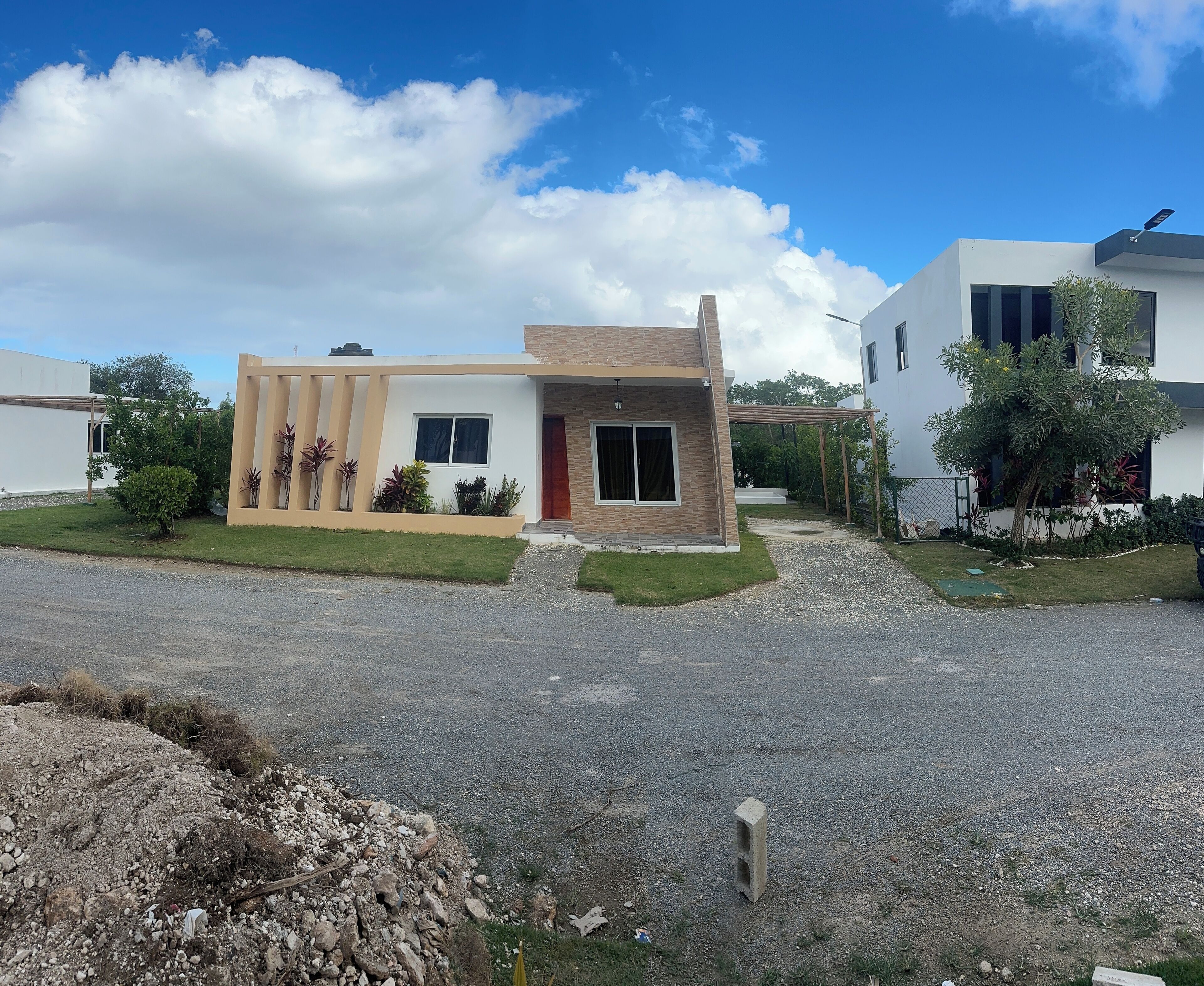 A modern two-story house with a paved driveway, a covered patio, and a well-maintained lawn.