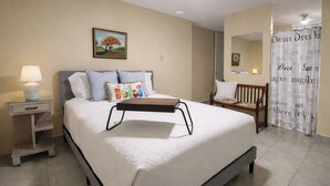 A bedroom with a bed, bedside table, lamp, and a painting on the wall. - Modern Villa on Puerto Rico's West Coast (Mayagüez)