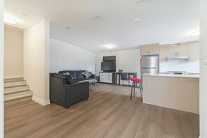 Eine moderne Wohnung mit Wohnbereich, Küche und einer Treppe.