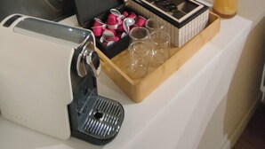 A room with a coffee machine, a tray with glasses, a potted plant, and a shelf with a candle. - L'oasis Noir, comfortable 50m2 apartment (Calonne-Ricouart)