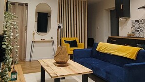 A modern living room with a sofa, a coffee table, and a TV. - L'oasis Noir, comfortable 50m2 apartment (Calonne-Ricouart)