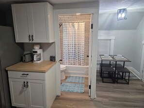 A compact kitchen with a toaster, coffee maker, and a sign on the counter. - Cozy 2-bed apt in Rochester near UR Campus, Highland Park, and Downtown (Rochester)