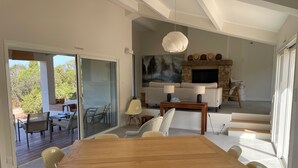 Un salon moderne avec une table à manger en bois, un canapé et une cheminée.