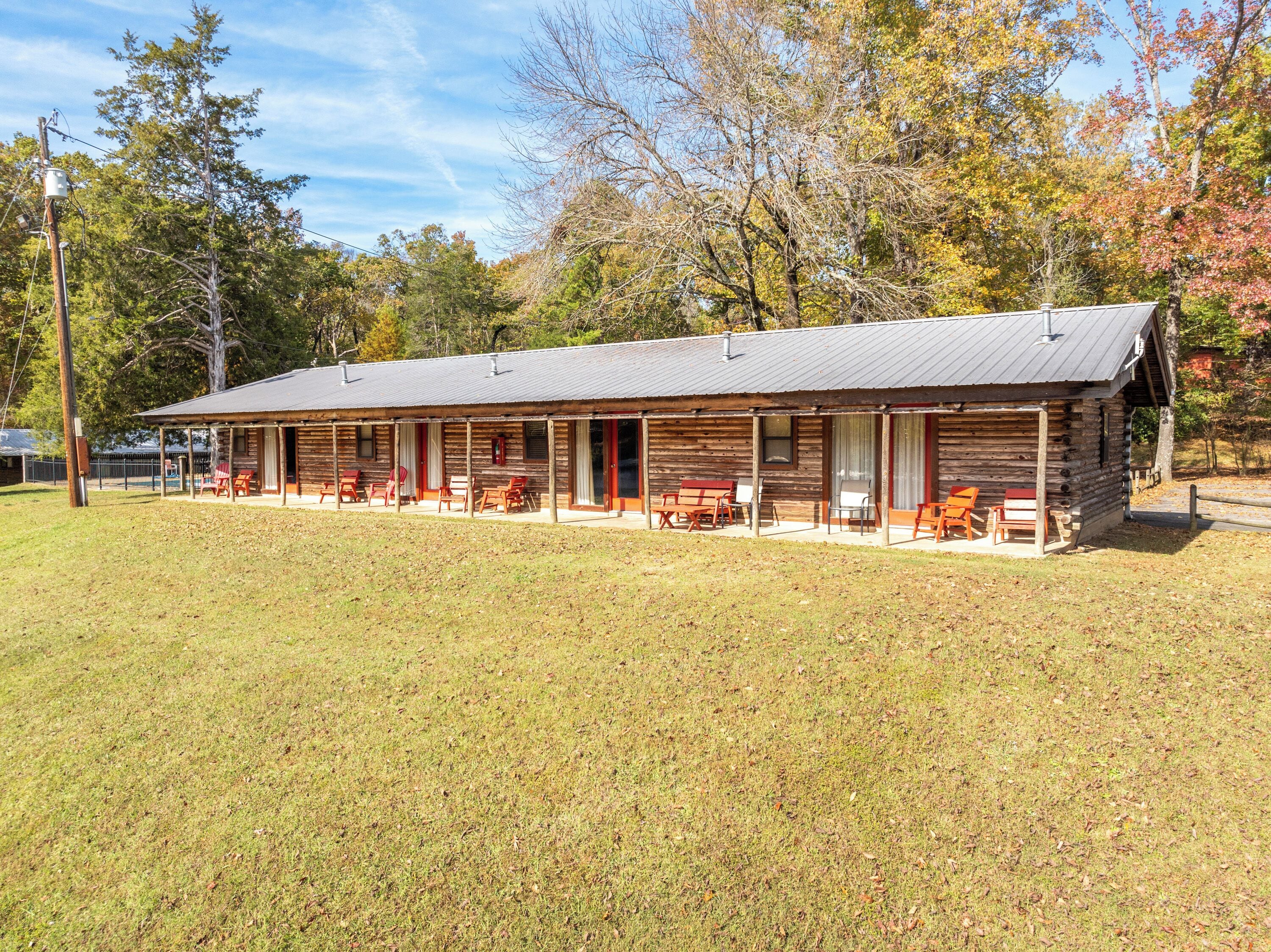 A log cabin with a covered porch and outdoor seating.