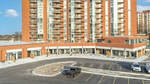 A multi-story residential building with a parking area in front. - Unit 3 - Modern Fully Furnished 3 Bedroom Apartment (Toronto)