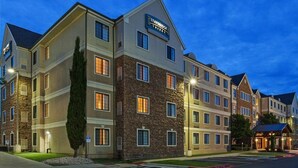 A multi-story hotel with a stone facade, multiple windows, and a sign indicating it is a Staybridge Suites hotel.