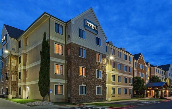 A multi-story hotel with a stone facade, multiple windows, and a sign indicating it is a Staybridge Suites hotel.