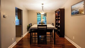 A dining area with a table, chairs, a chandelier, a bookshelf, and a painting on the wall. - Gorgeous 3-bedroom house with 2nd living rooms in charming Roswell (Roswell)