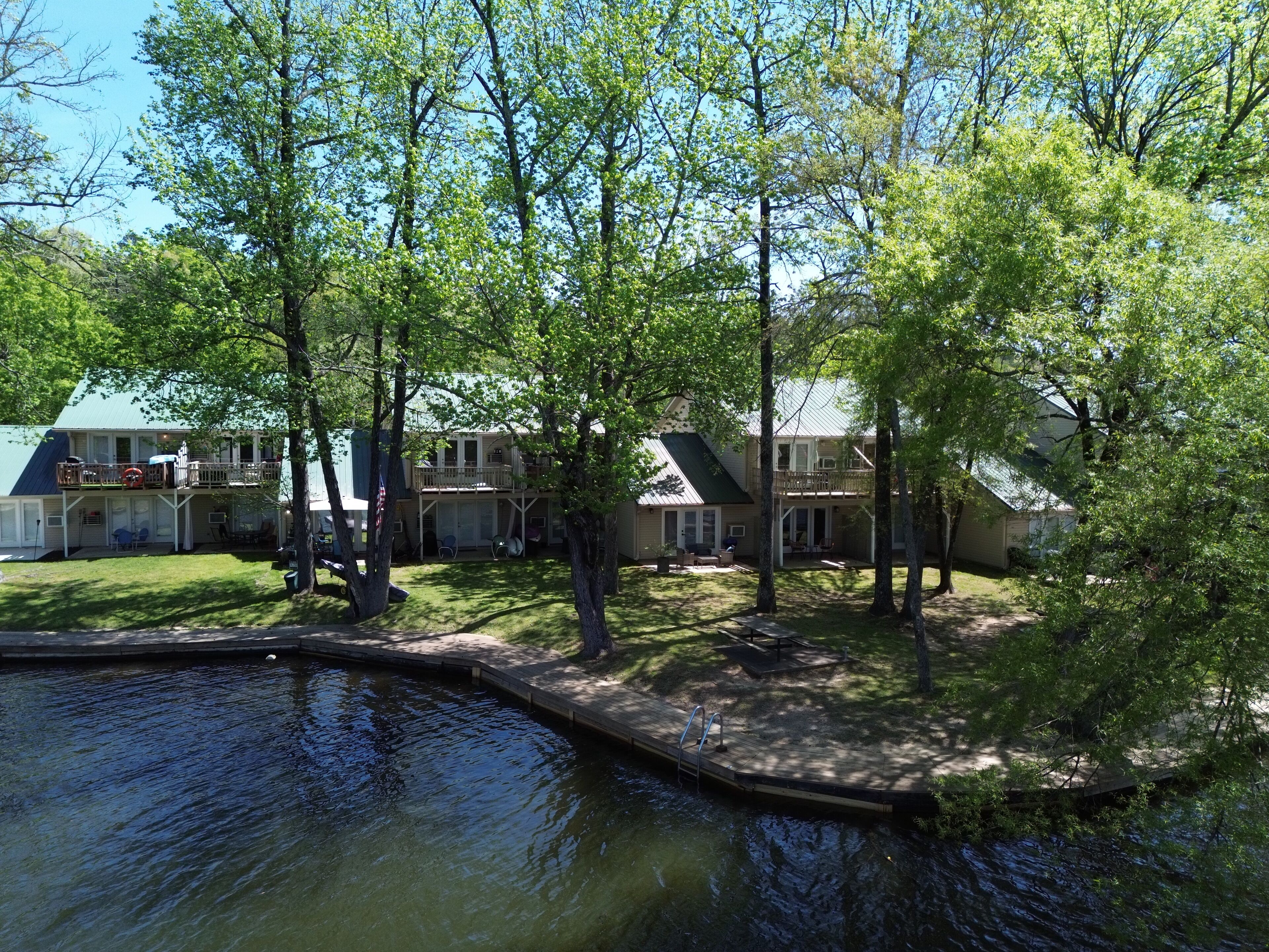 Área residencial com piscina, árvores e casas com varandas.