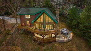 A cabin with a deck, a hot tub, and a stone fireplace. - Private Retreat w/ Views, Hot Tub + Game Room (Lenoir)