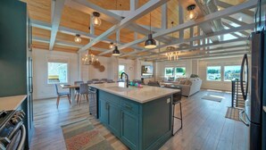 A spacious kitchen with a large island, wooden ceiling beams, and pendant lighting. - Third Sandbar & Seaglass Landing by Avantstay. Sleeps 30 2 Homes + Dual Pools + Outdoor Living Steps to Beach (Port Aransas)