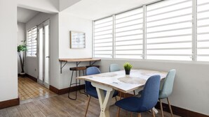 Uma área de refeições com mesa, cadeiras e uma planta.