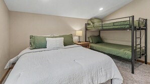 A room with a bunk bed, a single bed, and a nightstand with a lamp. - Deadwood Cabin-Sleeps 12-Hot Tub-4X4 Trails-Central (Deadwood)