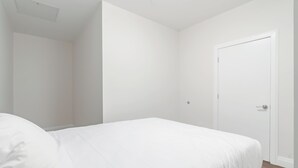 Une chambre à coucher avec un lit, une porte et un interrupteur sur le mur.