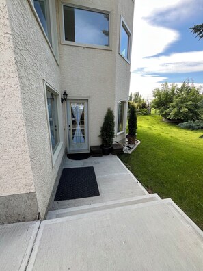 A two-story building with a front entrance, a small porch, and a well-maintained lawn. - 1 bdm walkout bsm suite Apto. (Calgary)