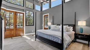 A bedroom with a large bed, two bedside tables, a nightstand, and a ceiling fan. - Summerset by Avantstay Resort Pool + Outdoor Lounge + Firepit + Movie Room IOP Beach Retreat (Isle of Palms)