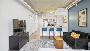 Ein modernes Apartment mit Wohnzimmer, Küche und Essbereich.