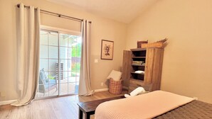 A bedroom with a bed, a wooden wardrobe, a window with curtains, and a view of the outside. - Vineyard Getaway 3BR Home in Lodi minutes away from shopping & attractions (Lodi)