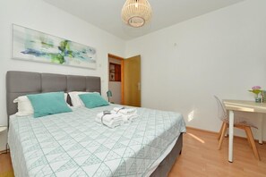 A bedroom with a bed, a desk, a chair, and a hanging light fixture. - One Bedroom Apartment Sleeps 2 - Private Garden (Zadar)