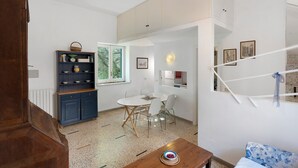 Ein Zimmer mit Esstisch, Stühlen, einem blauen Schrank und einem Holztisch mit einer Schüssel.
