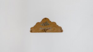 Ein hölzernes Schild mit der Aufschrift 'BALCONES' und einem dekorativen Blattmuster.