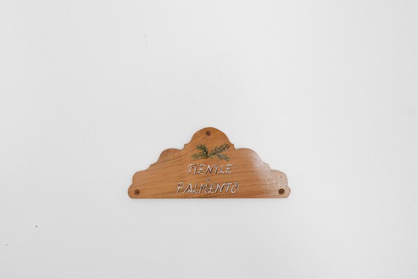 A wooden sign with the text 'TENILE e PALMENTO' and a decorative element. - Le Tore – Palmento Room with Private Terrace, Shared Garden and Wi-Fi (Massa Lubrense)