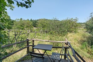 A rustic outdoor seating area with a table and benches, surrounded by a wooden fence and lush greenery. - Le Tore – Palmento Room with Private Terrace, Shared Garden and Wi-Fi (Massa Lubrense)