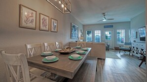 En matplats med ett långt träbord, stolar och en takfläkt.
