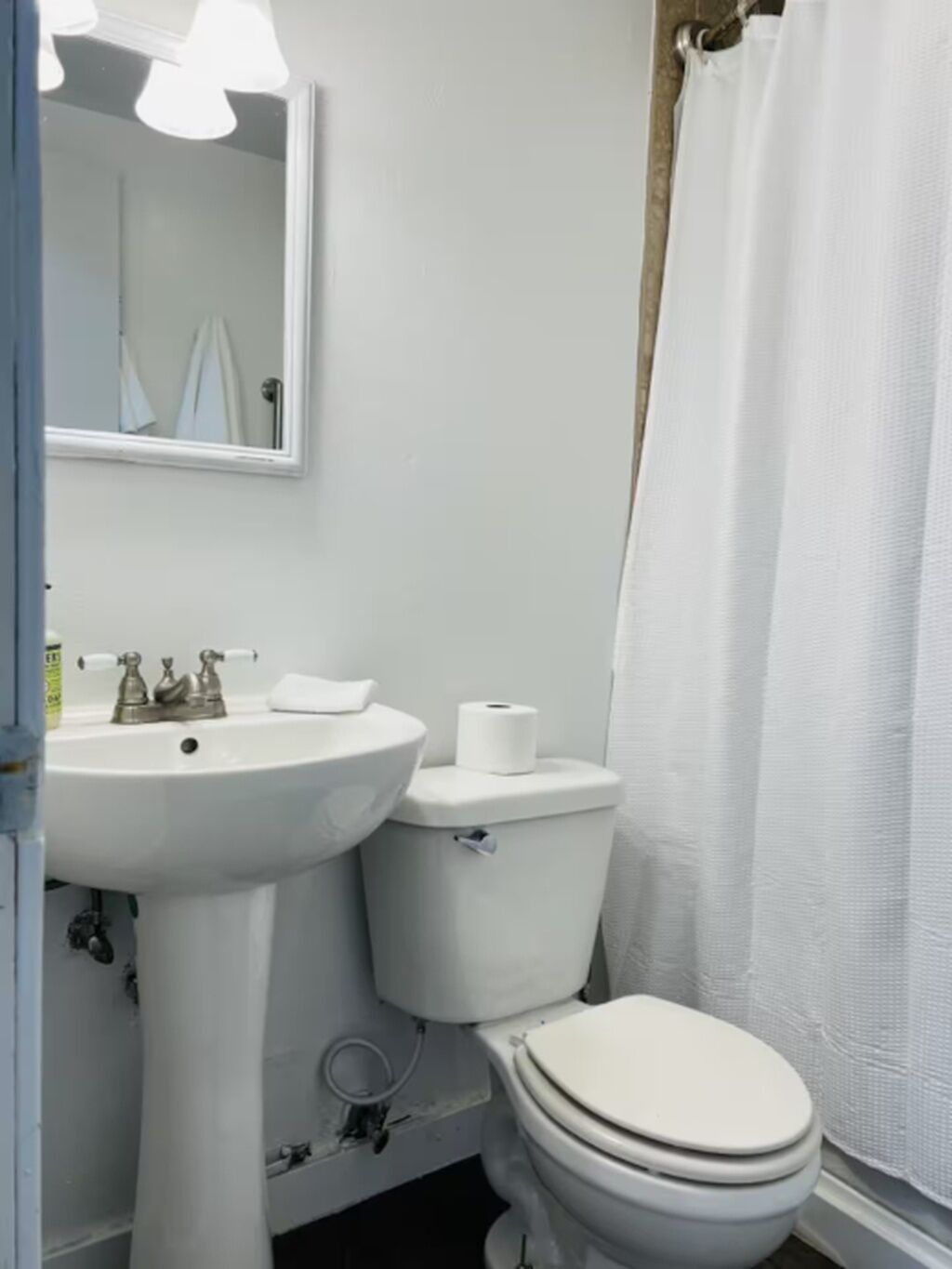Ein Badezimmer mit einem weißen Waschbecken, einer Toilette und einer Duschvorhang.