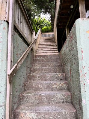 A wooden staircase with a handrail, leading to a covered area with a wooden roof. - The Saltwater-OceanView,Downtown (Kodiak)